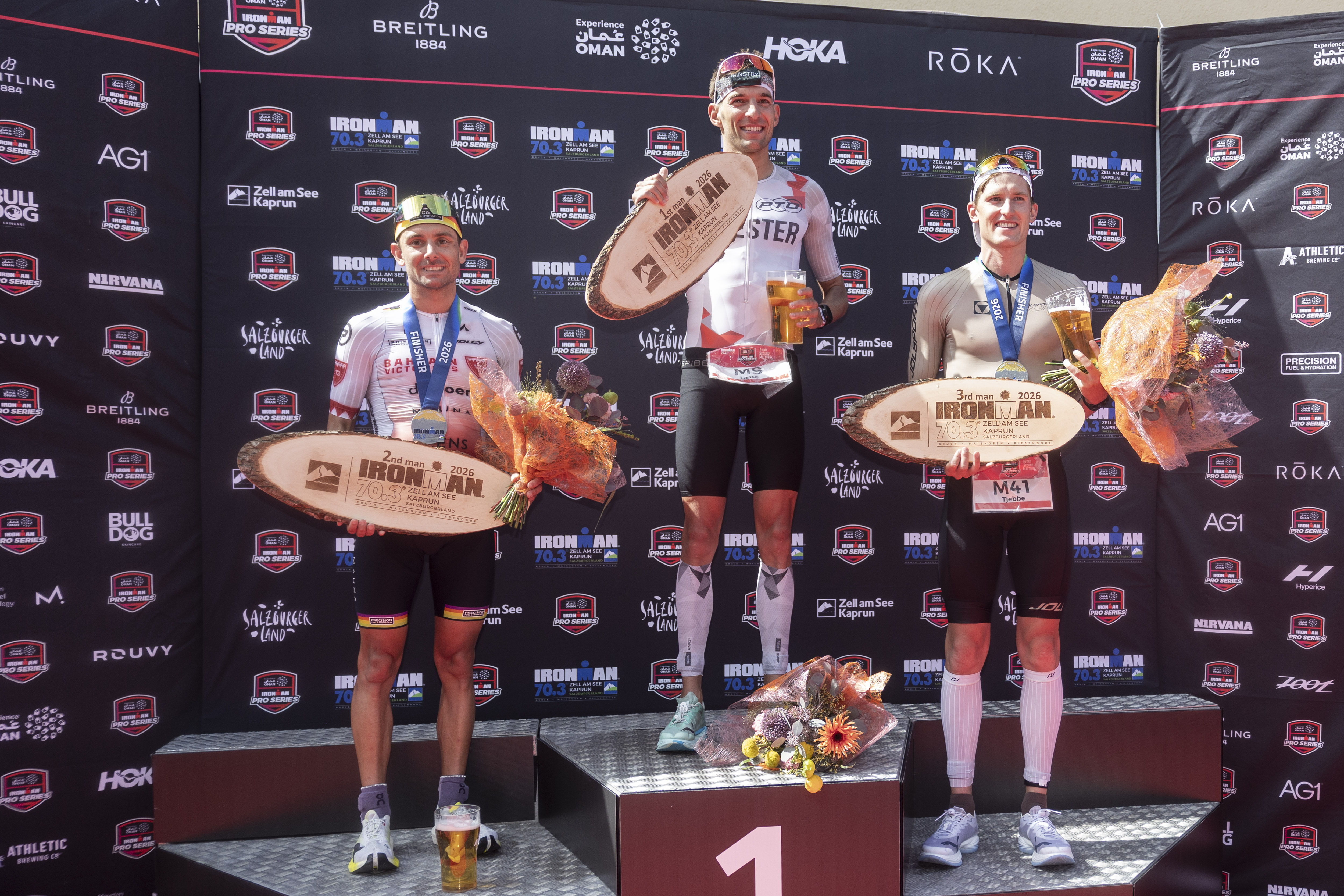 Jelle Geens aus Belgien, Lasse Nygaard Priester aus Deutschland und Tjebbe Kaindl aus Österreich posieren am 30. August 2026 auf dem Siegerpodium beim IRONMAN 70.3 Zell am See in Zell am See, Österreich, für ein Foto.