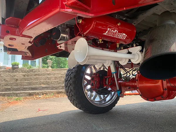 Red HornBlasters air tank and white train horns mounted on the rear undercarriage of Corbin's Ford F250