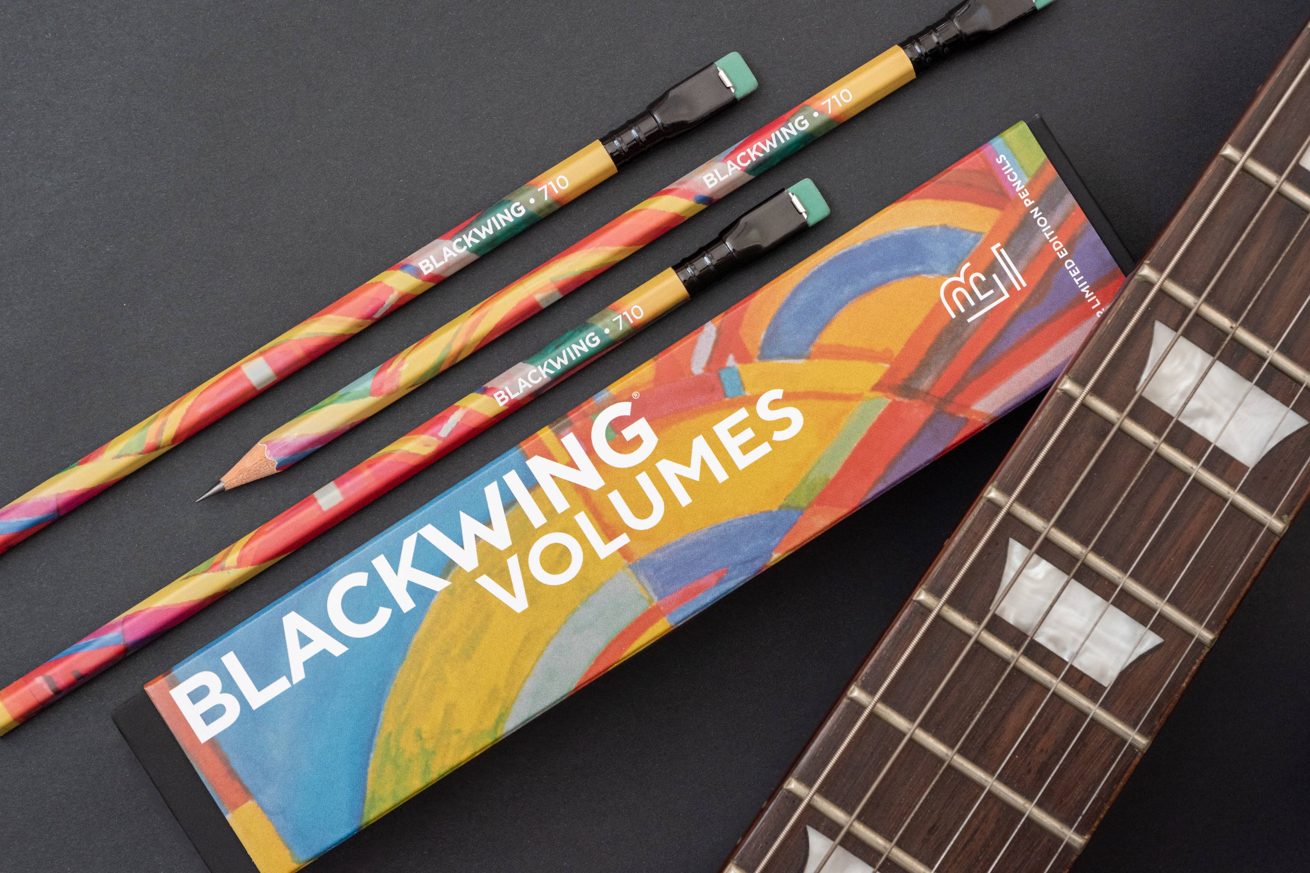 An image of Blackwing 710 pencils next to a guitar