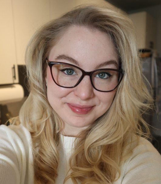 blonde girl with green eyes wearing Allure Brown Eyeglasses