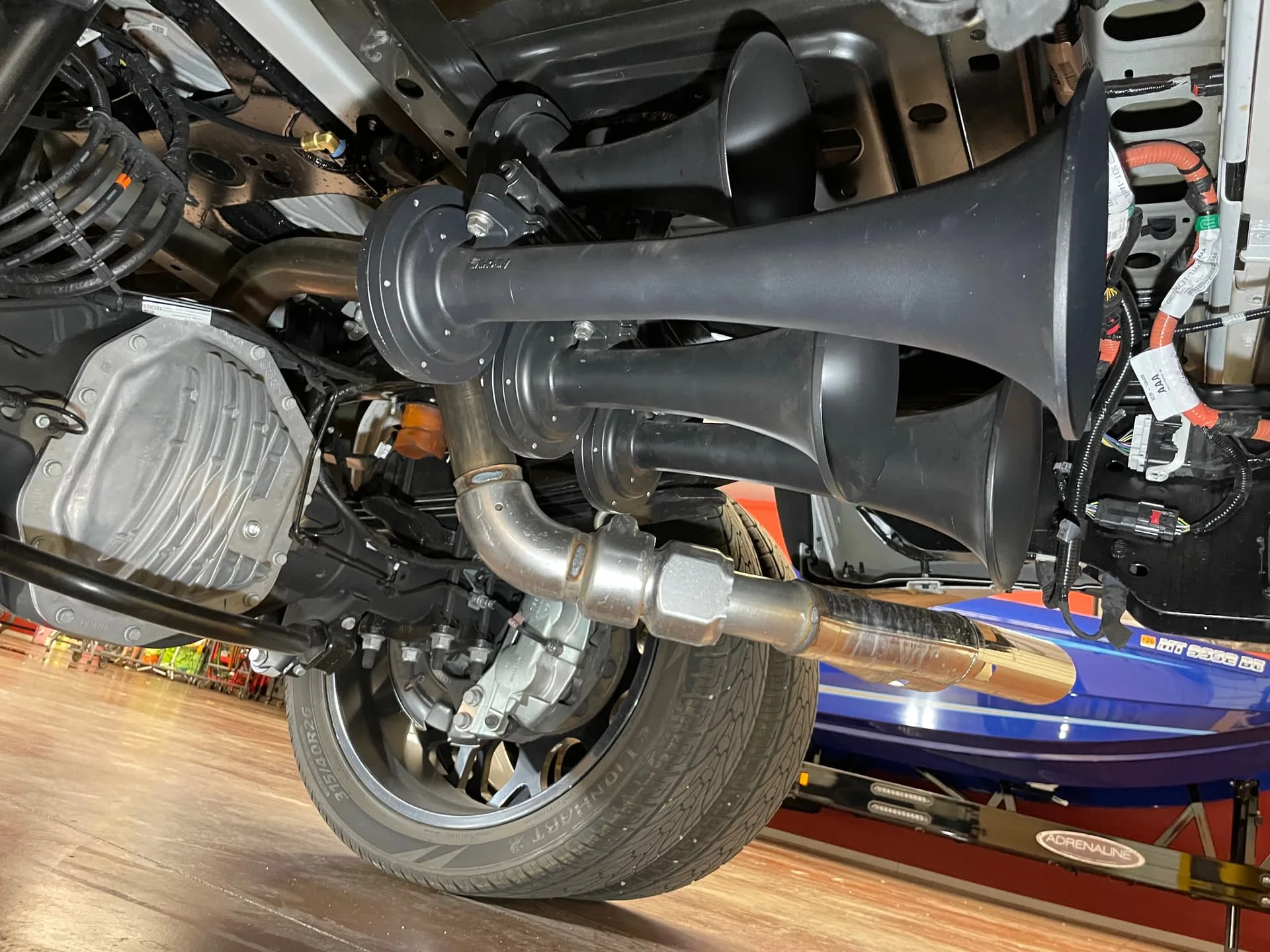 Four black train horns mounted near chrome exhaust and Lionhart tire on Robert's Ford F450 photo 10