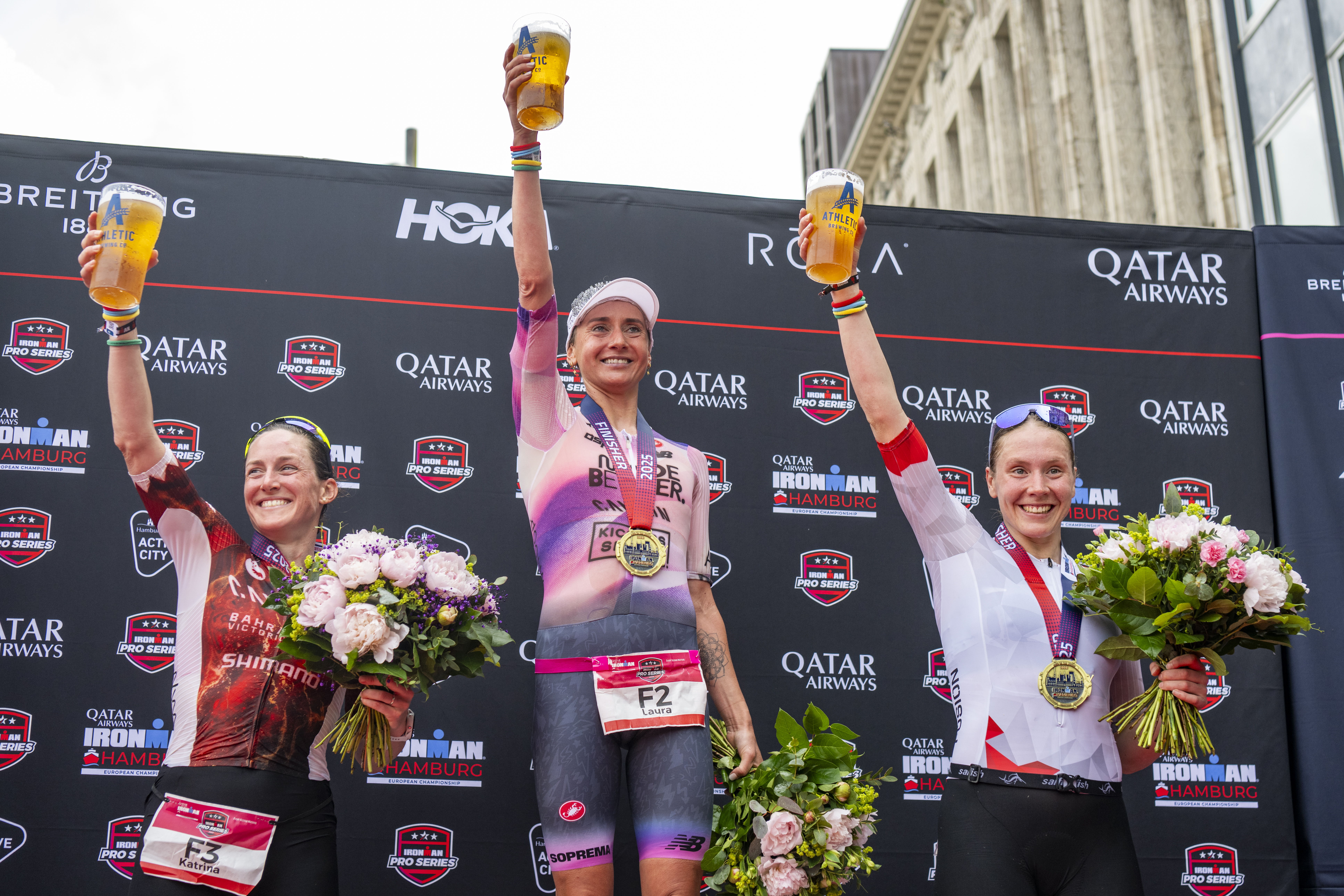 Die Podiumsplatzierten des Ironman Hamburg aus dem Jahr 2025 lächeln glücklich in die Kamera.
