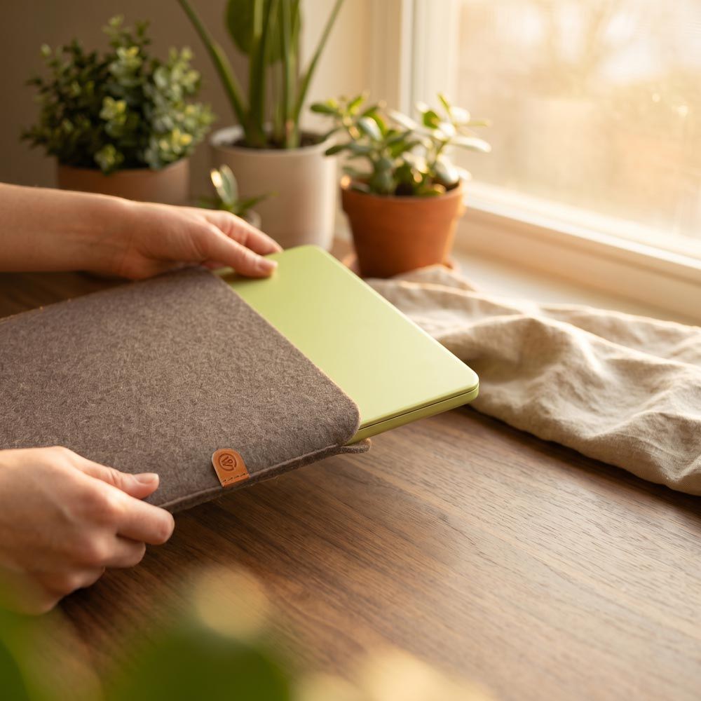 Eine Person hält eine Macbook Neo Hülle aus Wollfilz in der Hand