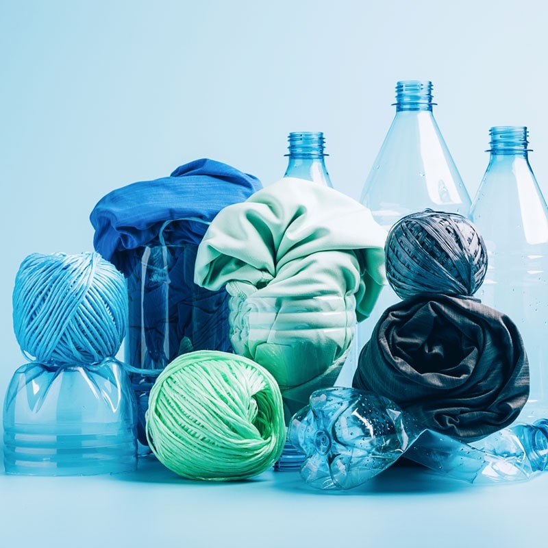 Used plastic bottles next to polyester yarns.