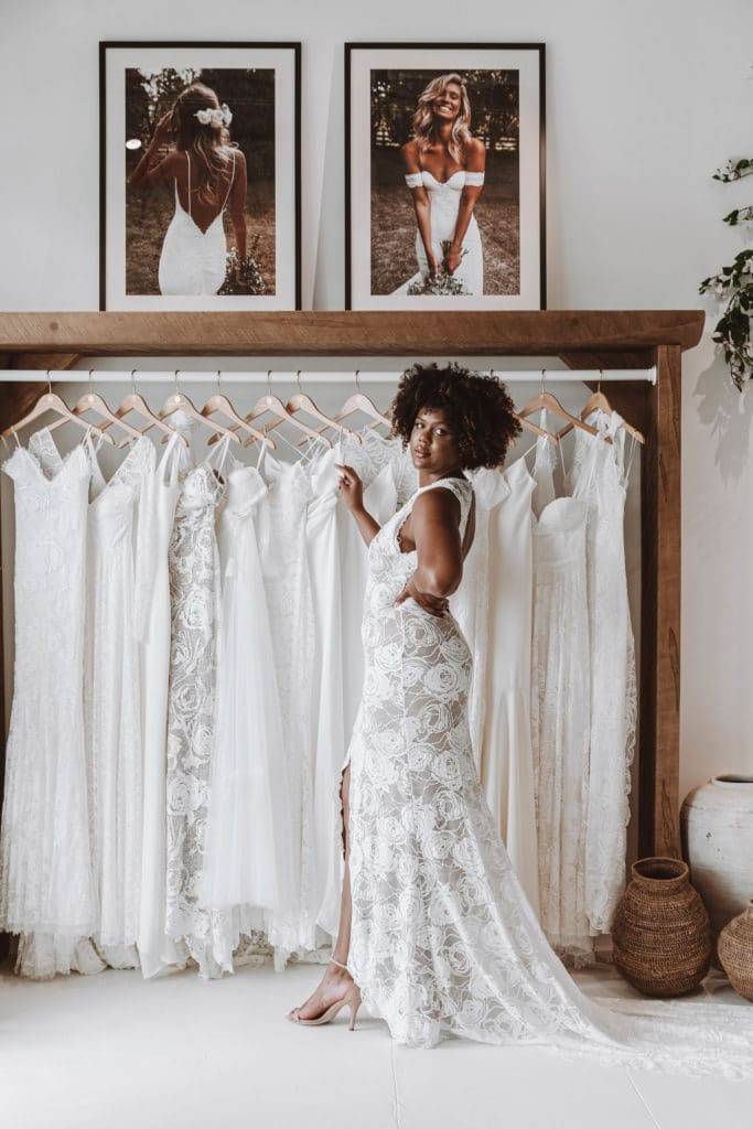 Bride walking through wedding dress boutique