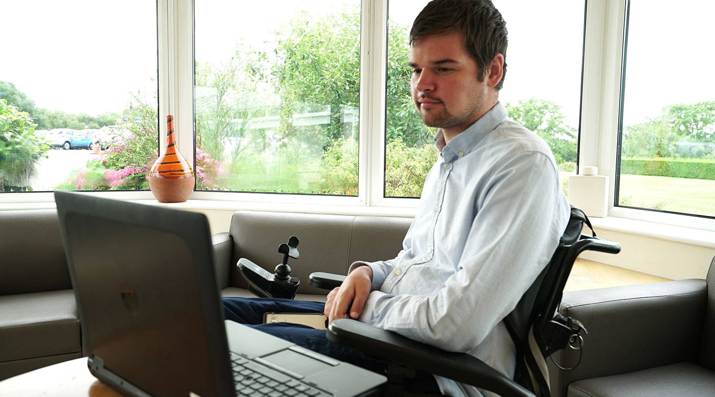 A man using Boardmaker 7 on his laptop