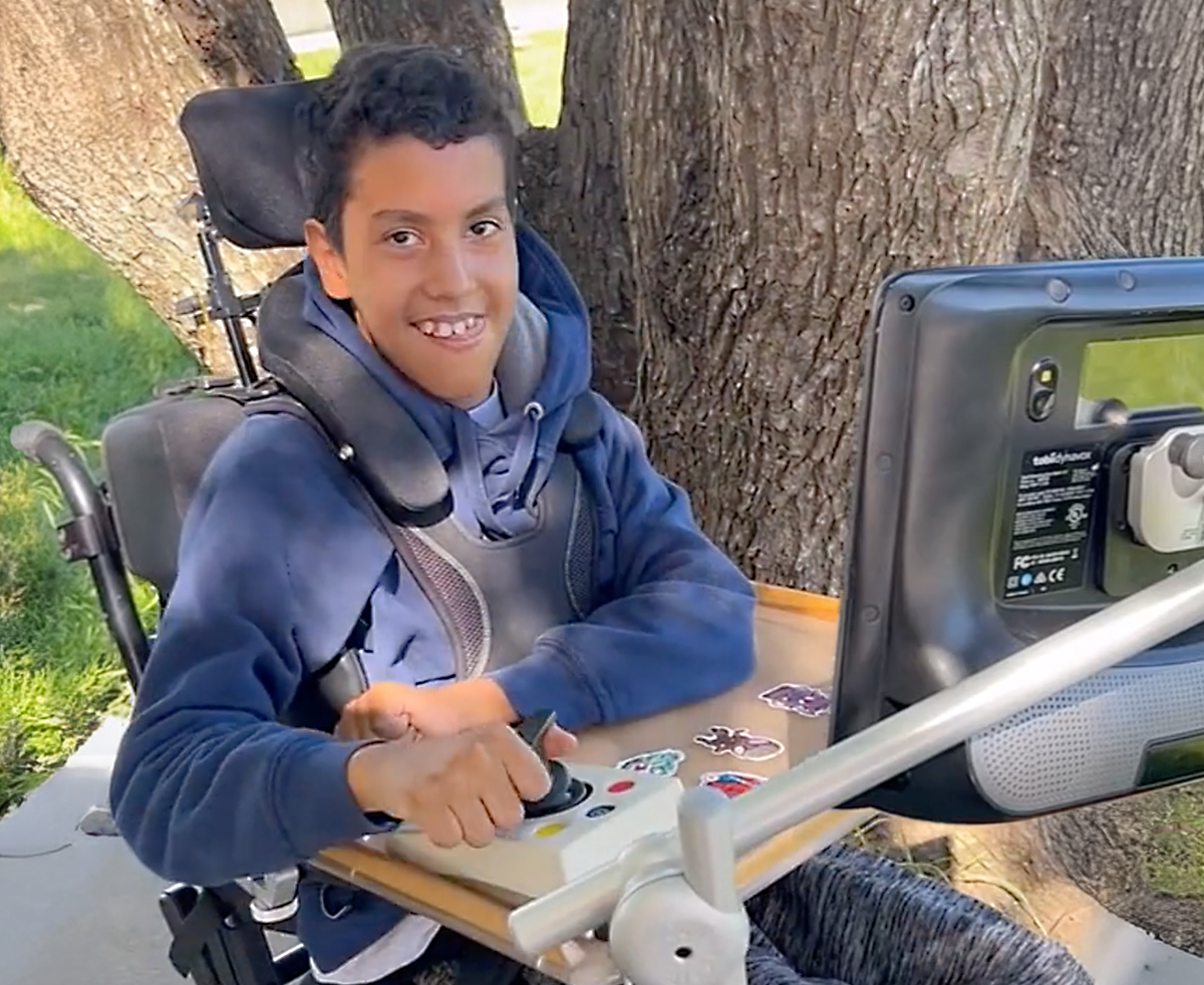 Boy using mouse dwell access with a joystick on a Tobii Dynavox assistive communication device