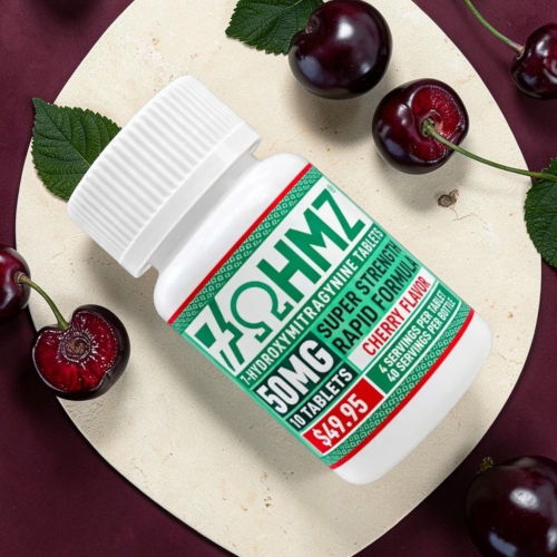 Bottle of cherry-flavored gummies with cherries and green leaves on a surface.