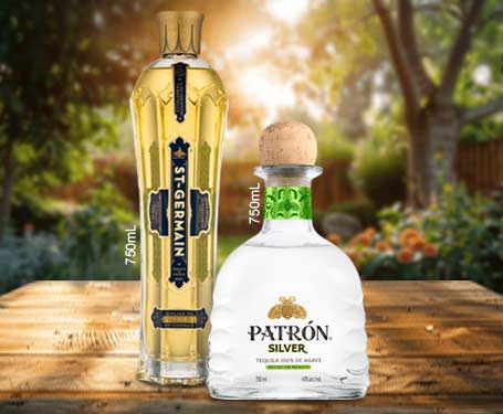 Two bottles of tequila on a wooden table in a garden setting.
