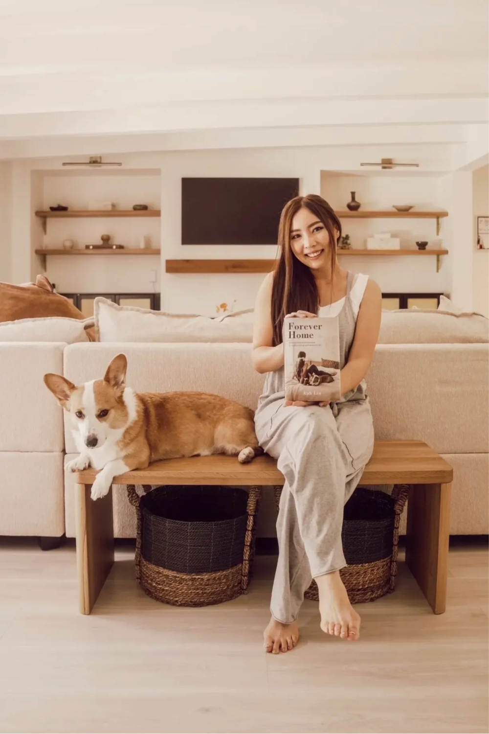 Anh Lin sitting next to her dog, holding a copy of Forever Home