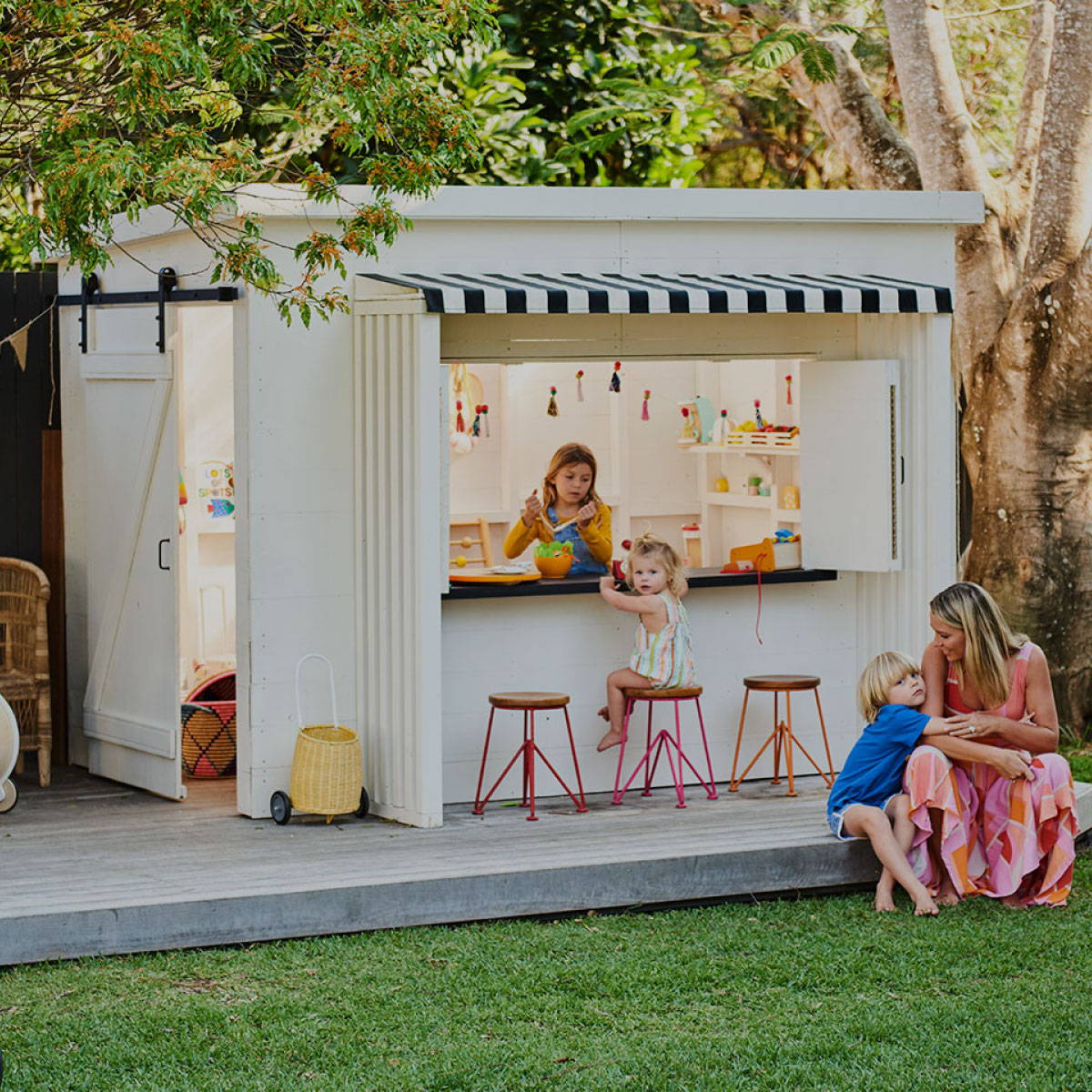 Woman and a kid sitting in front of the Mini Zimi Cubby Houses, Premium Cubby Houses