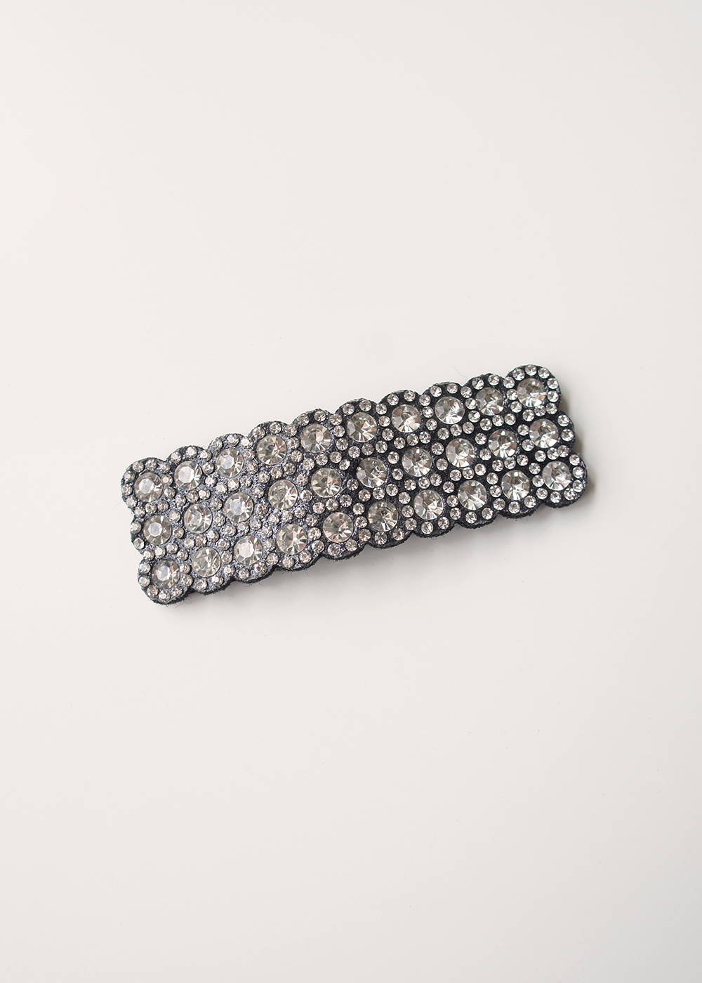 An oversized rectangular hair clip covered in different sized silver diamantés