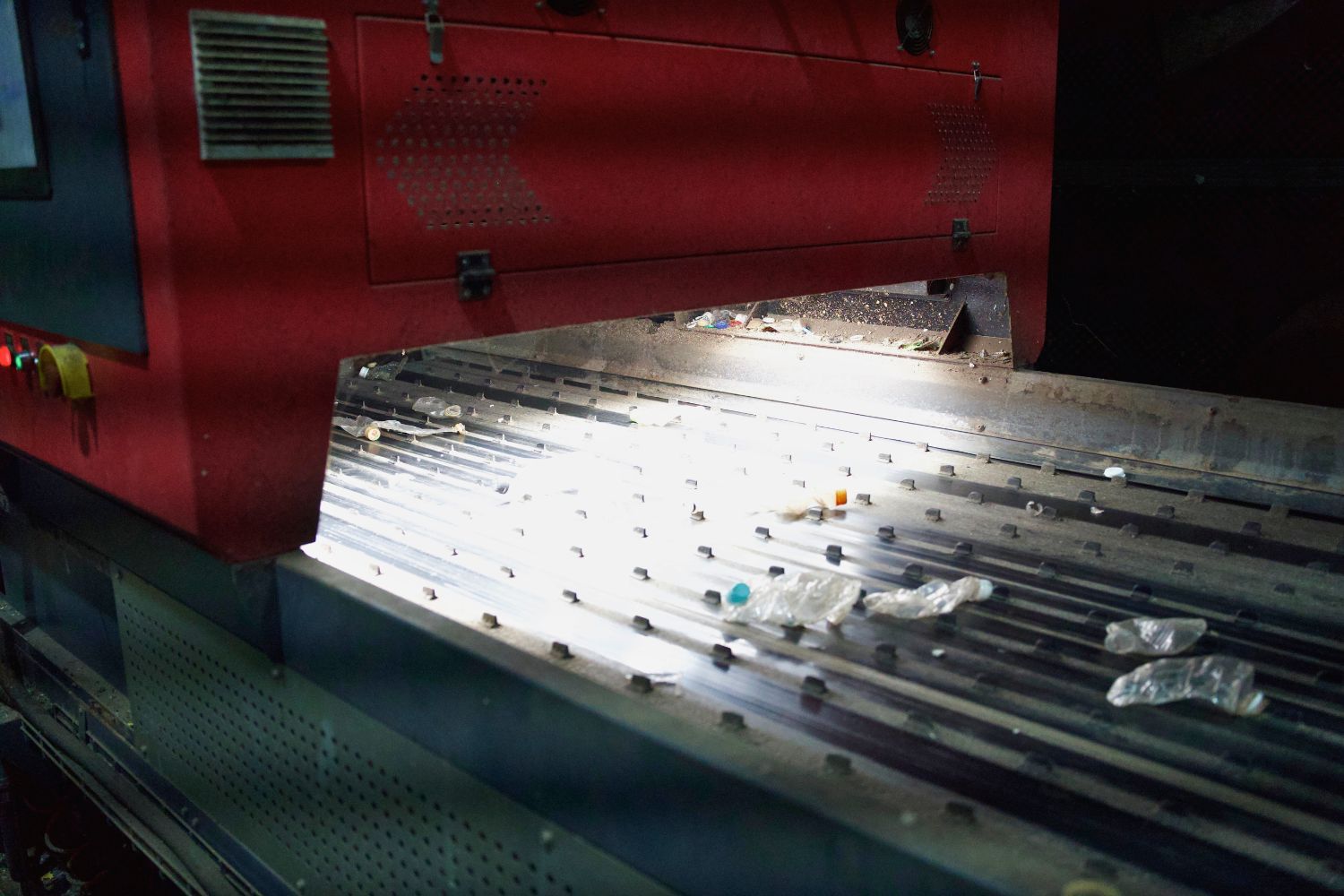 Conveyor belt with items moving under a machine in a factory setting.