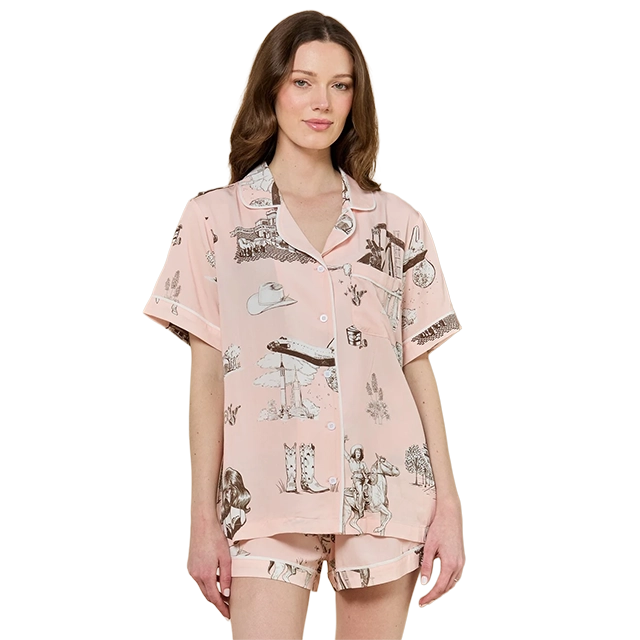 Woman wearing a pink pajama set with playful patterns.