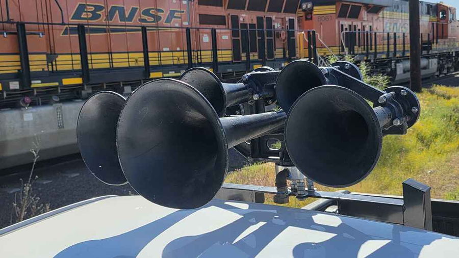 Close-up Nathan AirChime P5 black horn bells on roof rack of Max's 2009 Toyota Tacoma with BNSF locomotive in background gallery photo 3