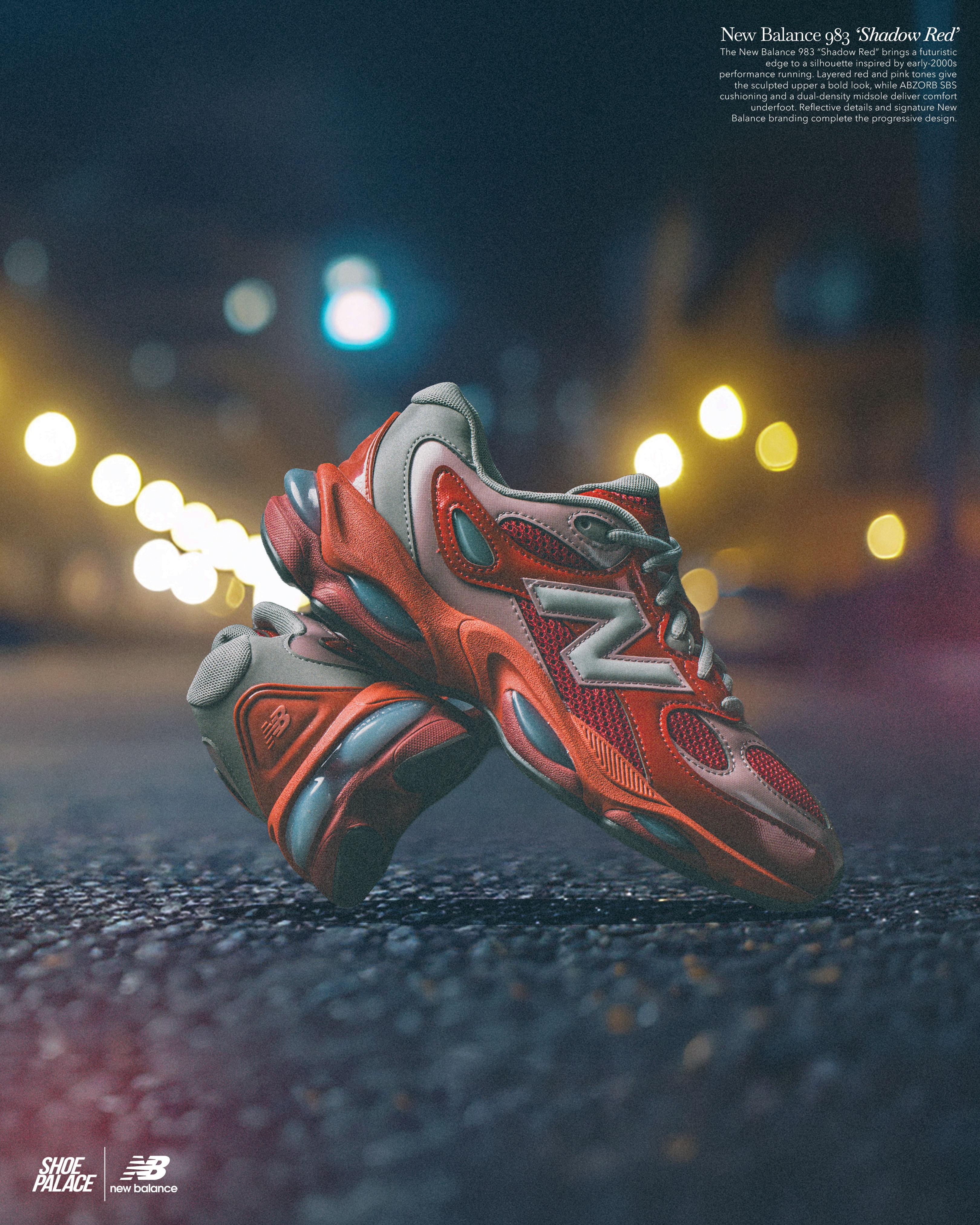 A pair of red and gray New Balance sneakers on a dark street.