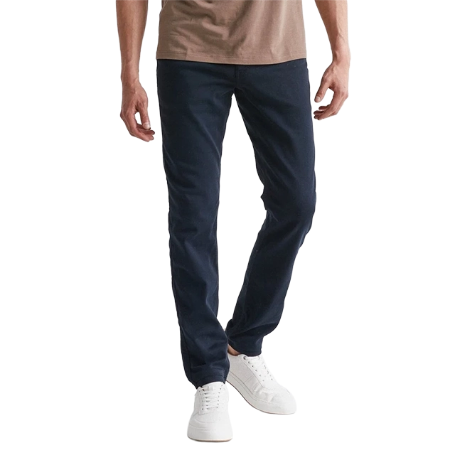 A person wearing navy pants and white sneakers, standing casually.