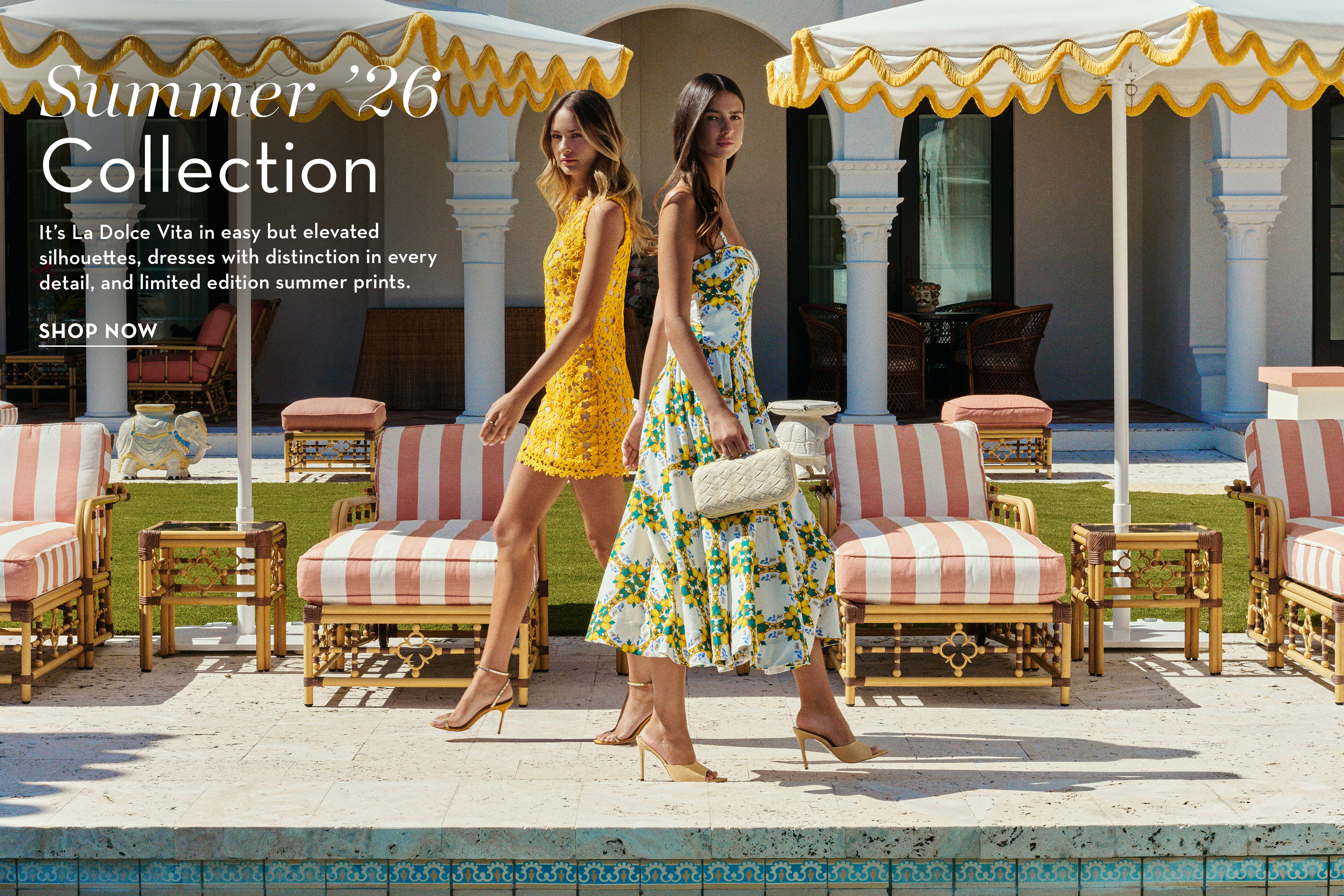 Two women in summer outfits walking by a poolside.