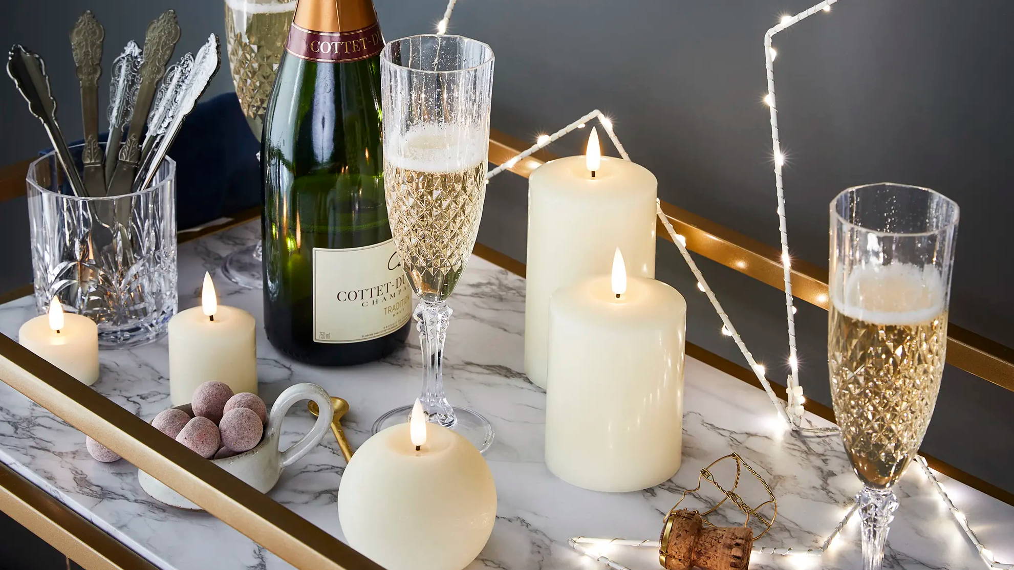 Star light and TruGlow candles styled as part of New Year's table with champagne glasses 