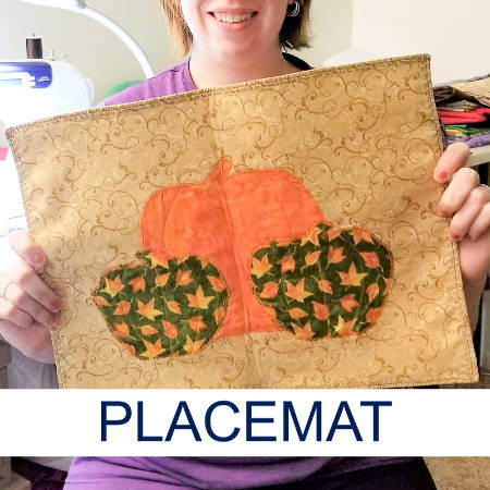 Women holding an autumn placemat with appliqued pumpkins
