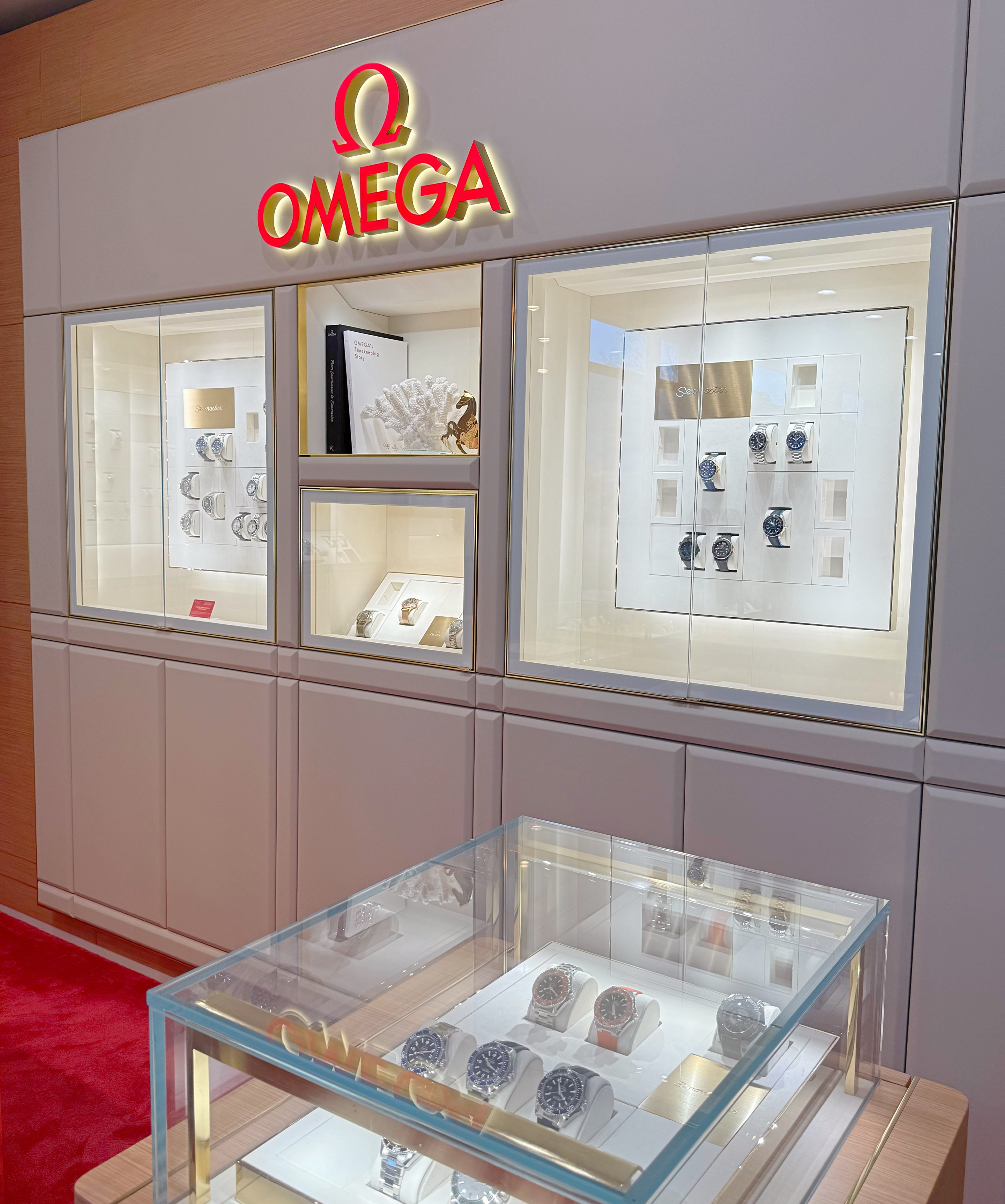 Omega watch display case with various timepieces and accessories.