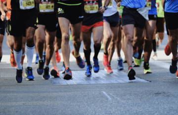 Runners' feet in motion during a race on pavement.