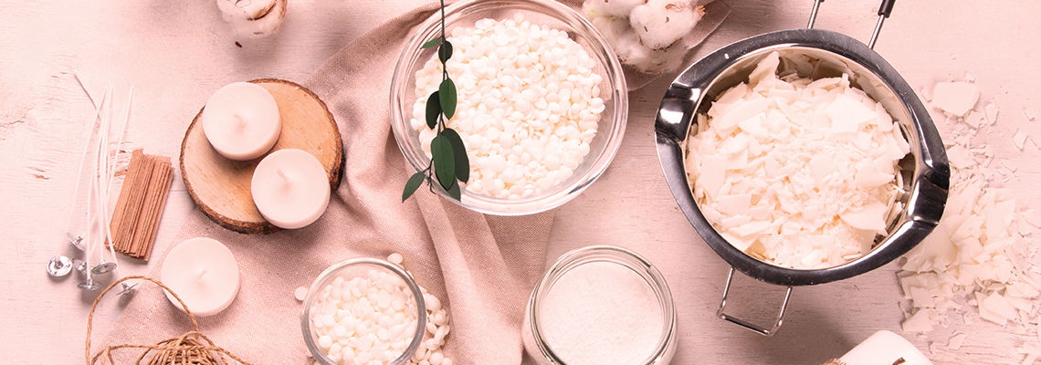 Various bowls and containers of skincare ingredients on a pink background.