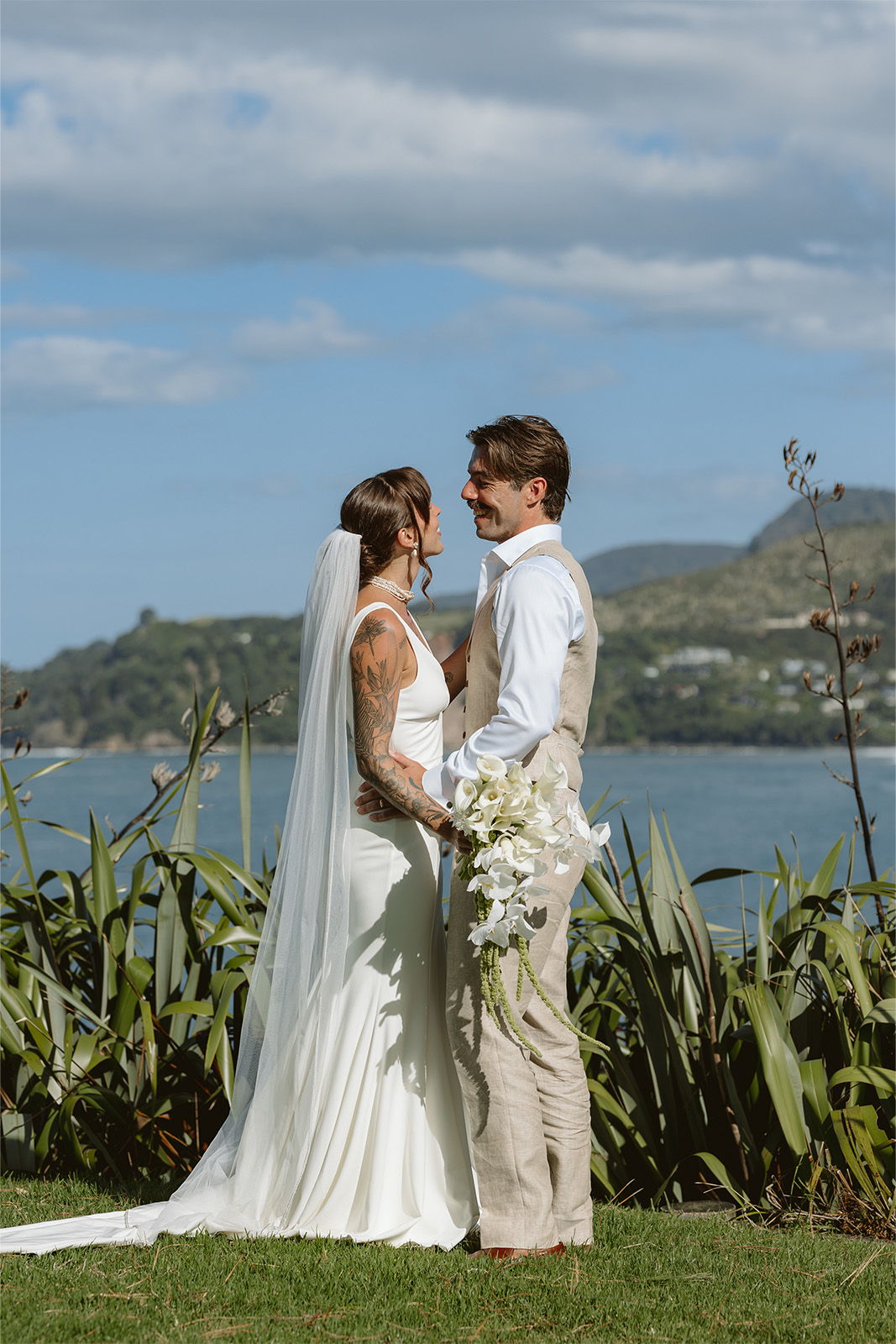 Bride and groom exchanging vows with a scenic background.