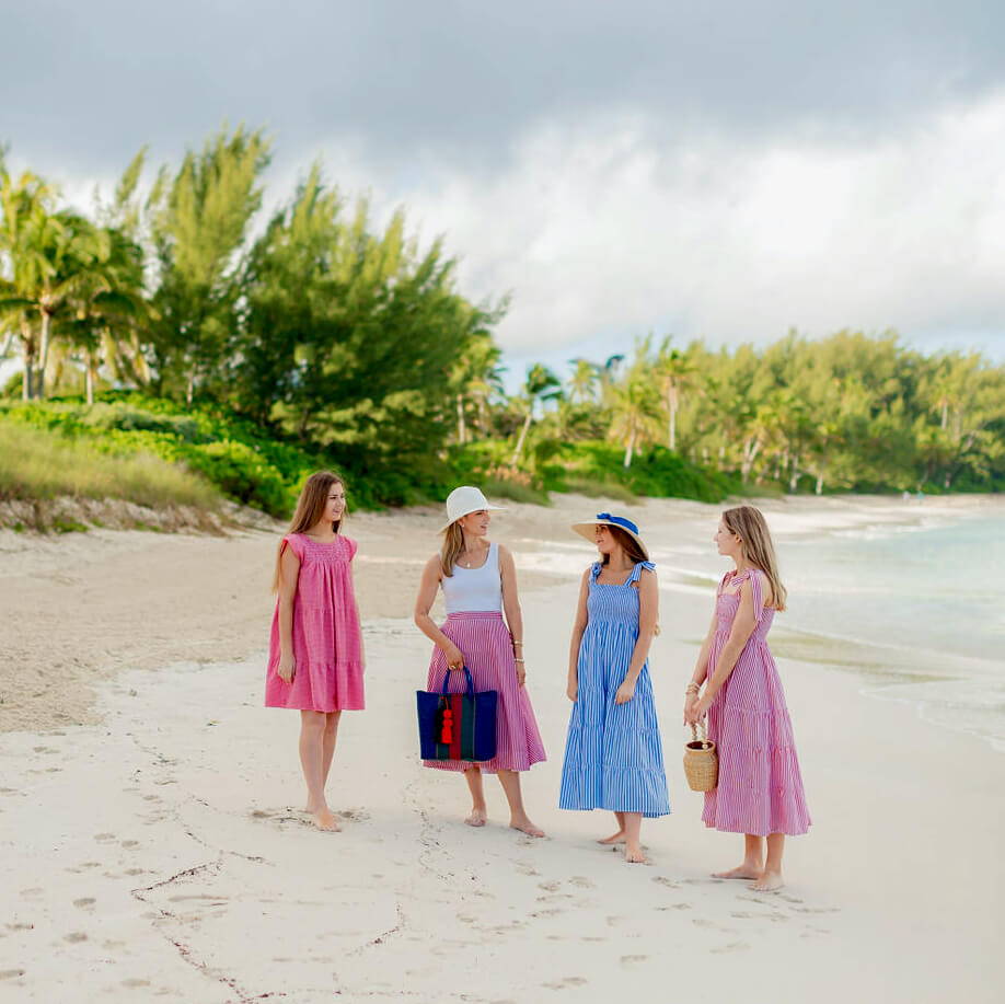4 women in beautiful M&G dresses on the beach