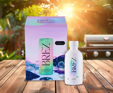 Brez product packaging with bottle on wooden surface, outdoor background, and grill.