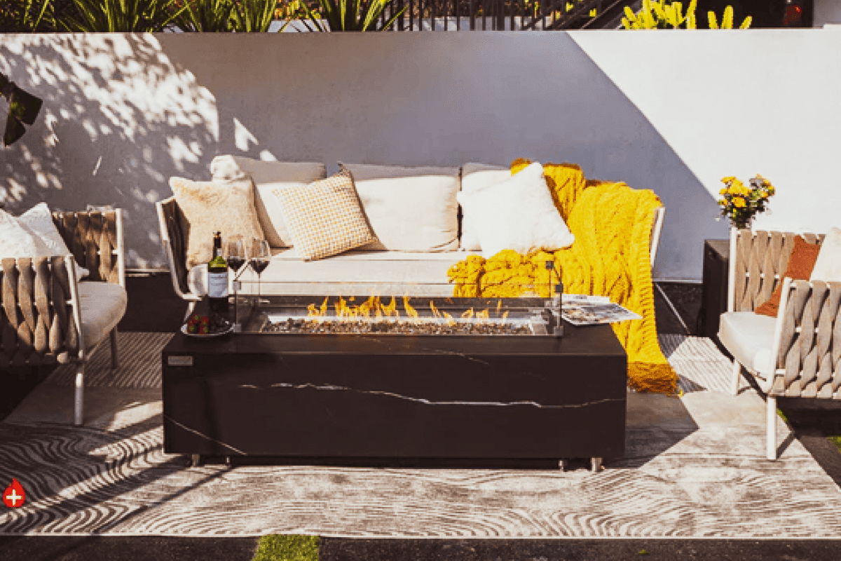 Modern rectangular outdoor fire pit table with sofa seating, lounge chairs, and patio accessories.