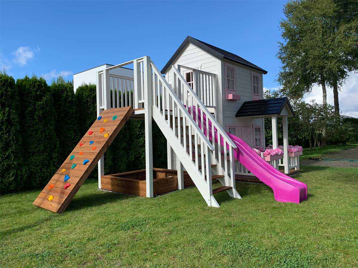 2- story Wooden Playhouse with climbing wall, pink slide, wooden balcony and cozy porch by WholeWoodPlayhouses