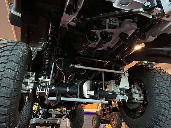 Rear undercarriage view of Eric's lifted 2018 Ford F250 showing custom suspension, differential cover, and HornBlasters train horns
