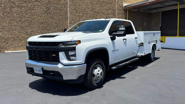 Alternate front three-quarter view of George's white 2022 Chevy Silverado 3500 HD service truck outside the building, install photo 4