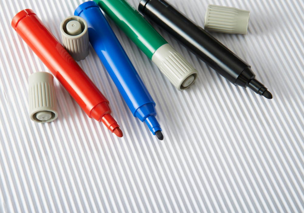 blue, red, green, and black whiteboard markers with caps off