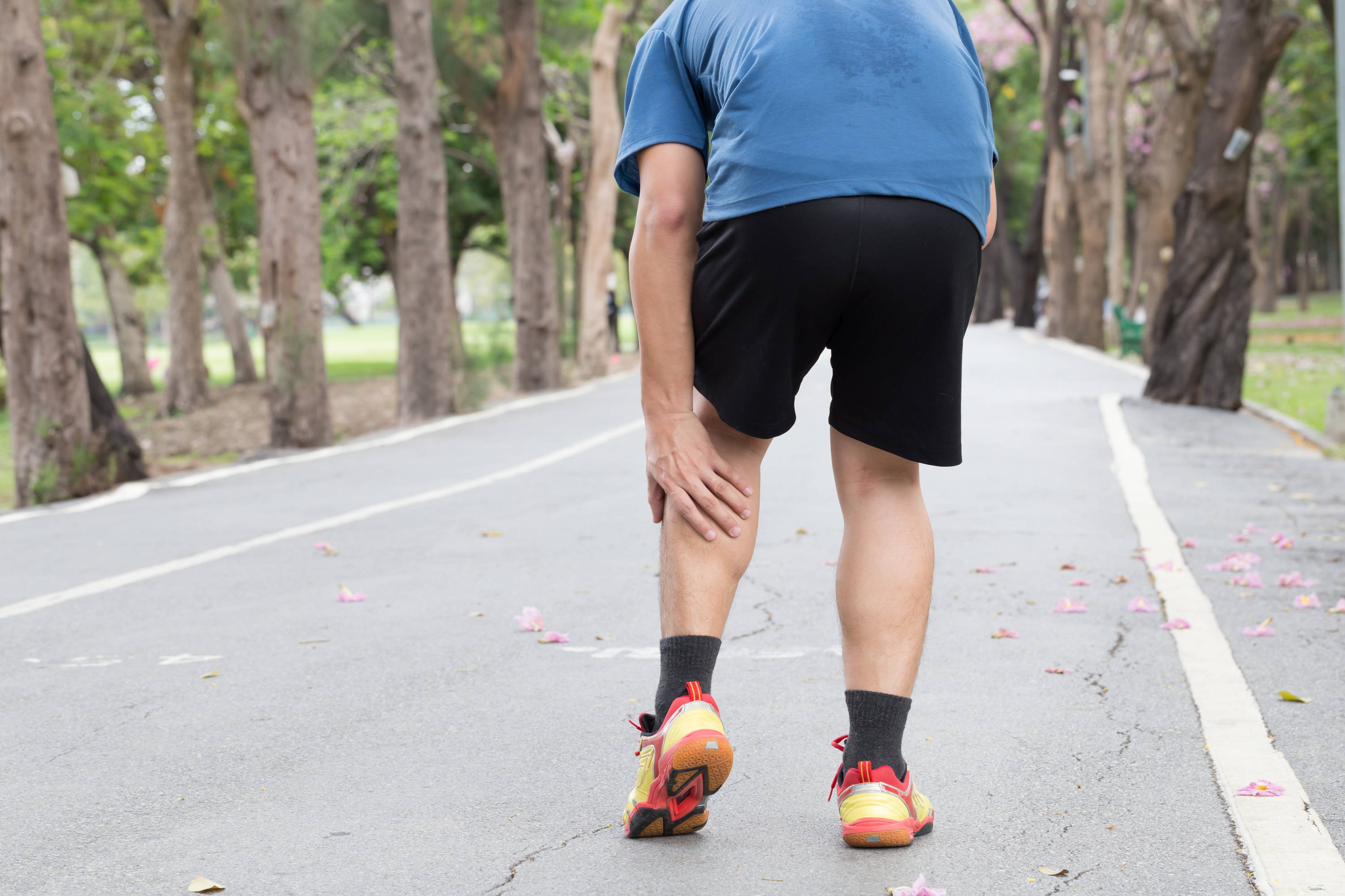 Man holding leg on the street, man with leg pain