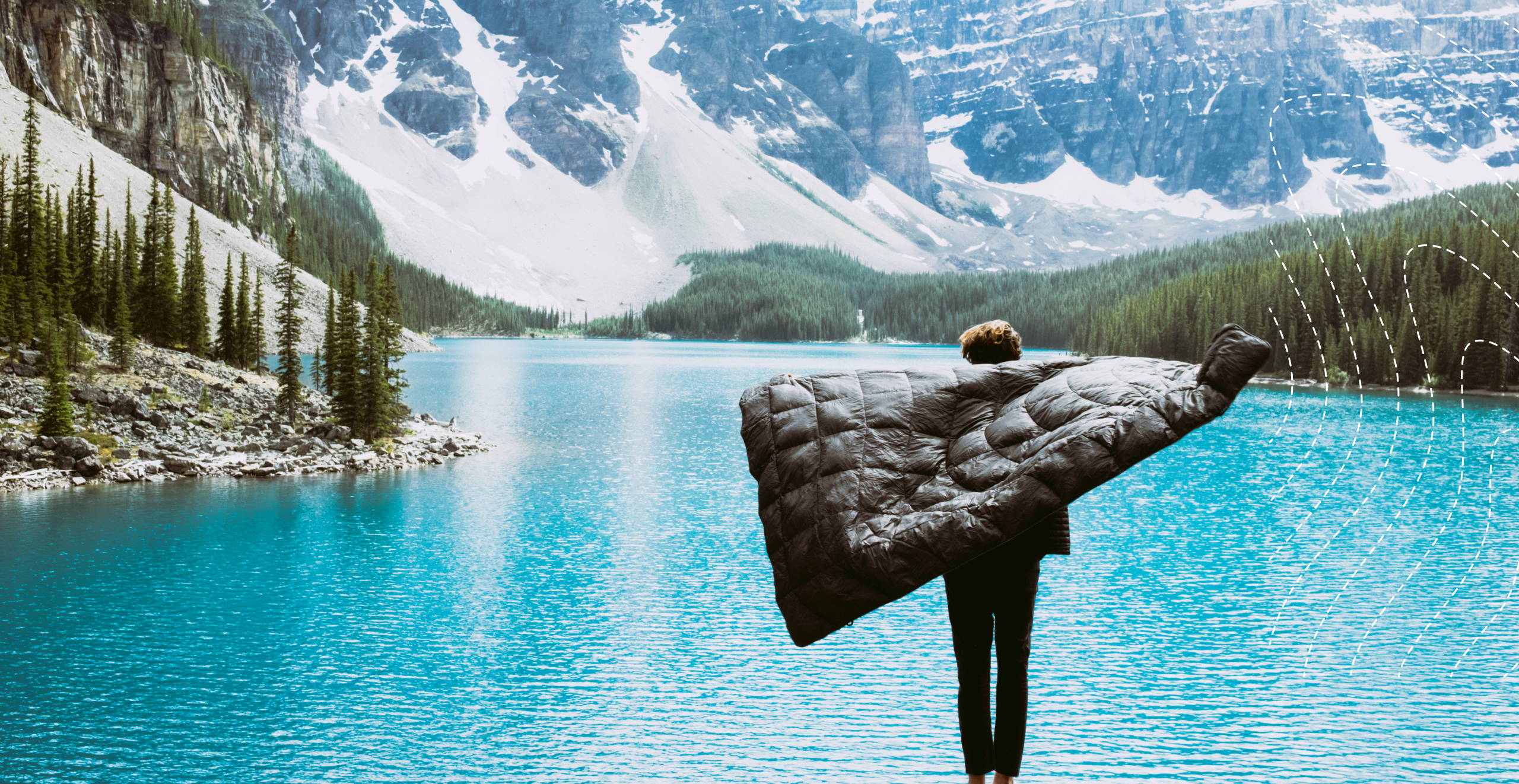 A man standing in front of a lake and holding a Rumpl blanket.