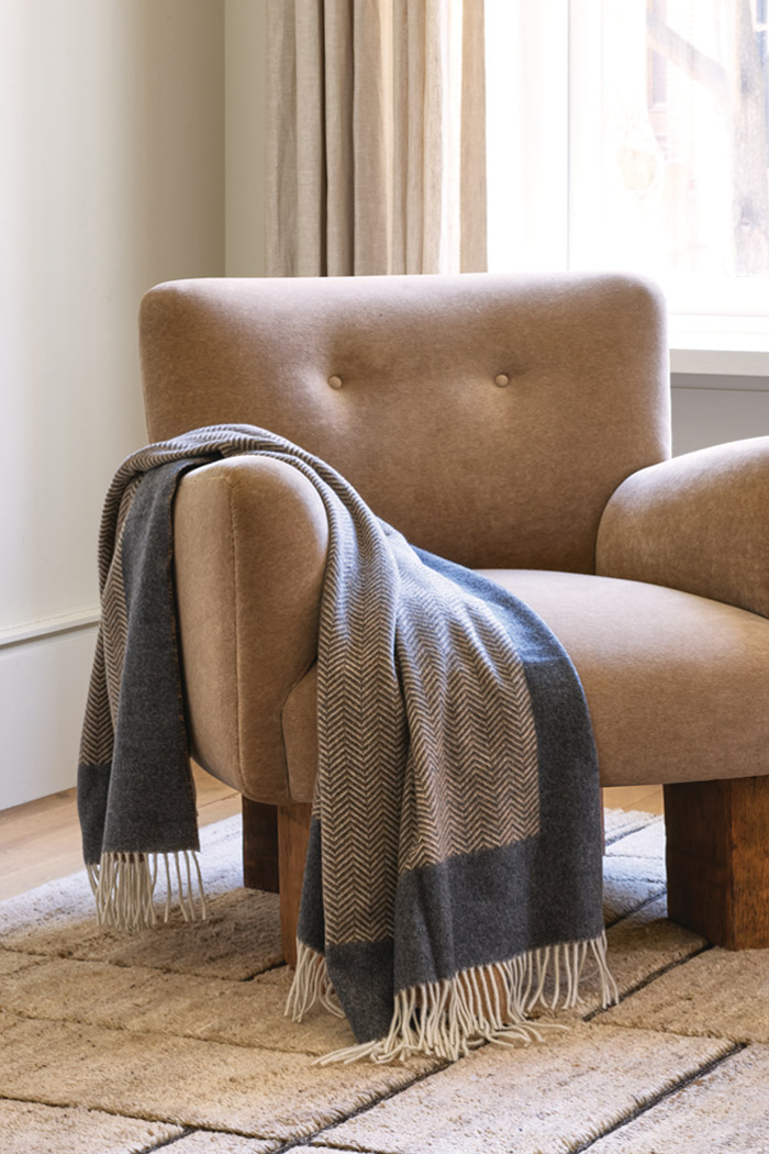 Cozy chair with warm wool luxury throw blanket on Tasha rug.