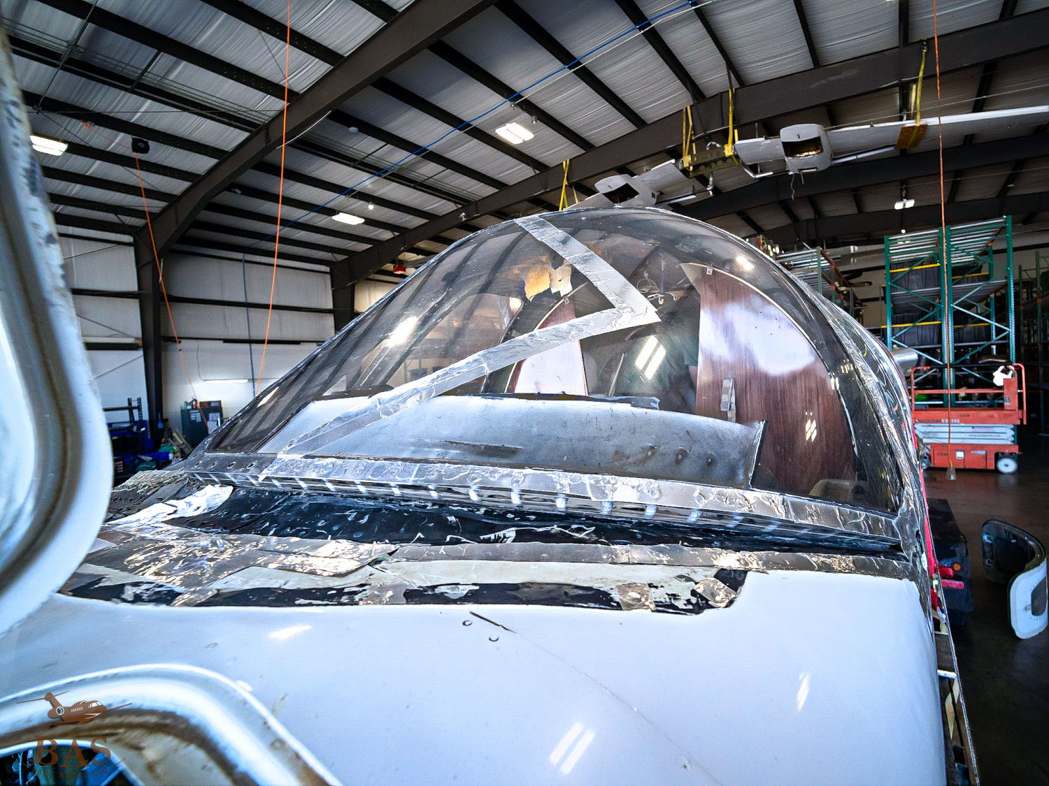 Cockpit of an aircraft in a hangar, showing the glass canopy.