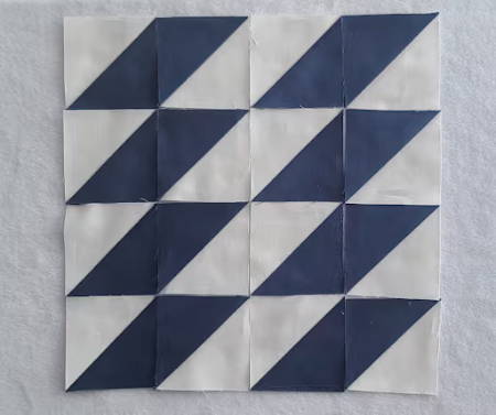 a half square triangle layout for a quilt block with blue and white triangles