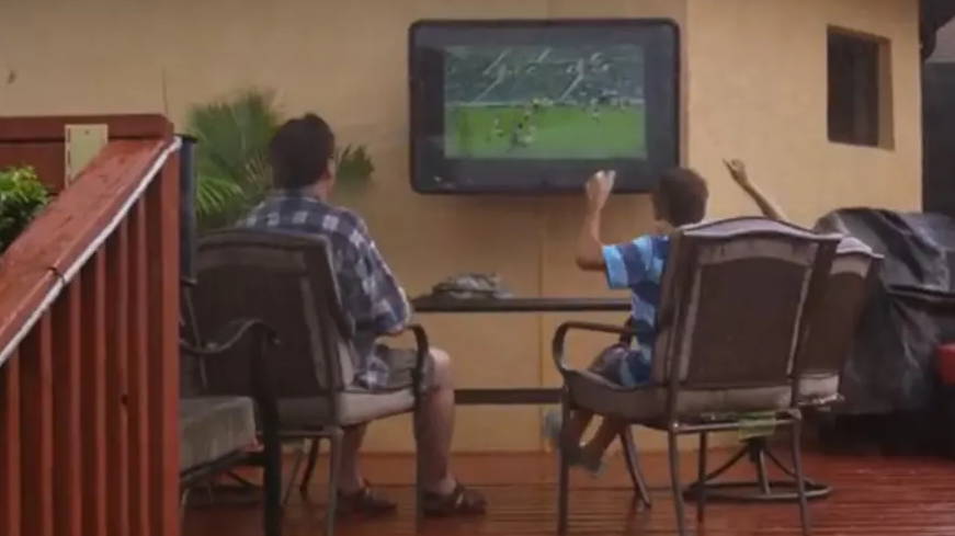 Father and son watching rain resistant TV The TV Shield