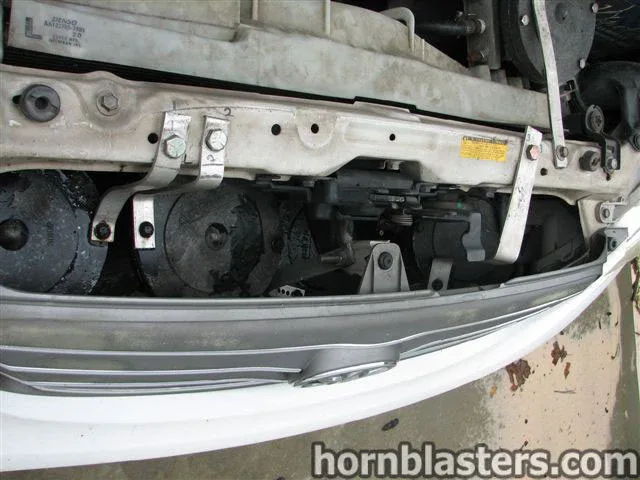 Three black horns mounted behind grille radiator support brackets 2001 Toyota Corolla K5LA train horn gallery photo 5