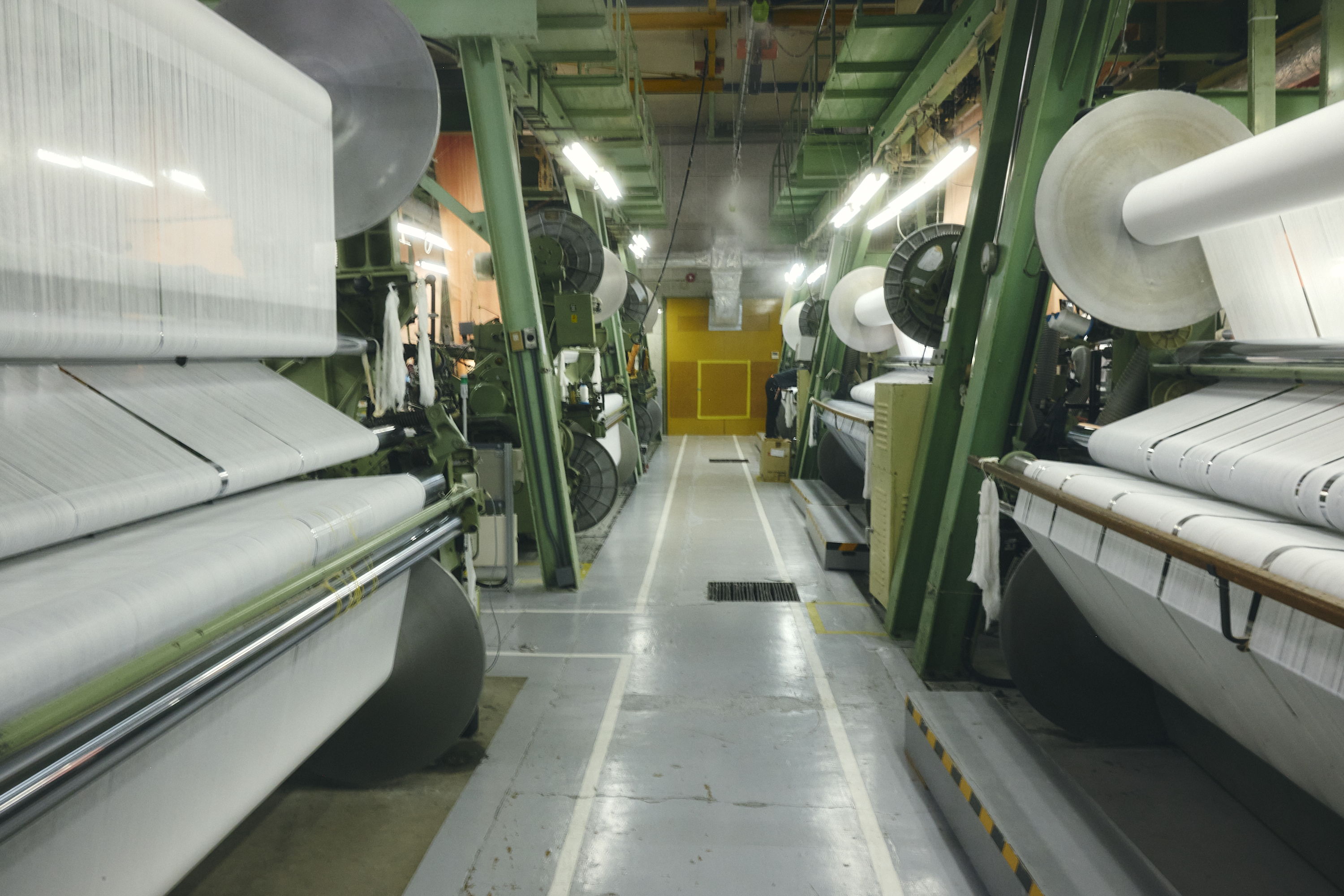 Textile manufacturing facility with machines aligned in a spacious interior.