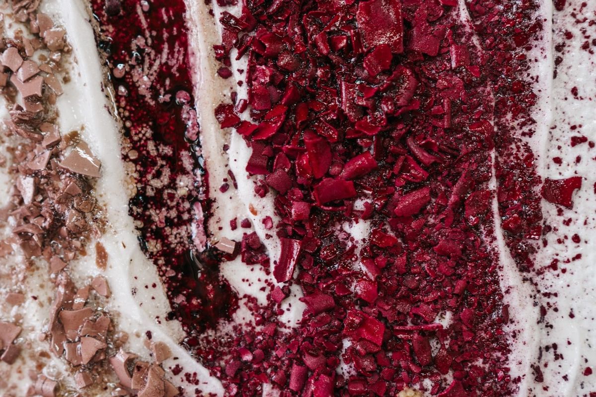 Close-up of colorful spices sprinkled on a creamy surface.