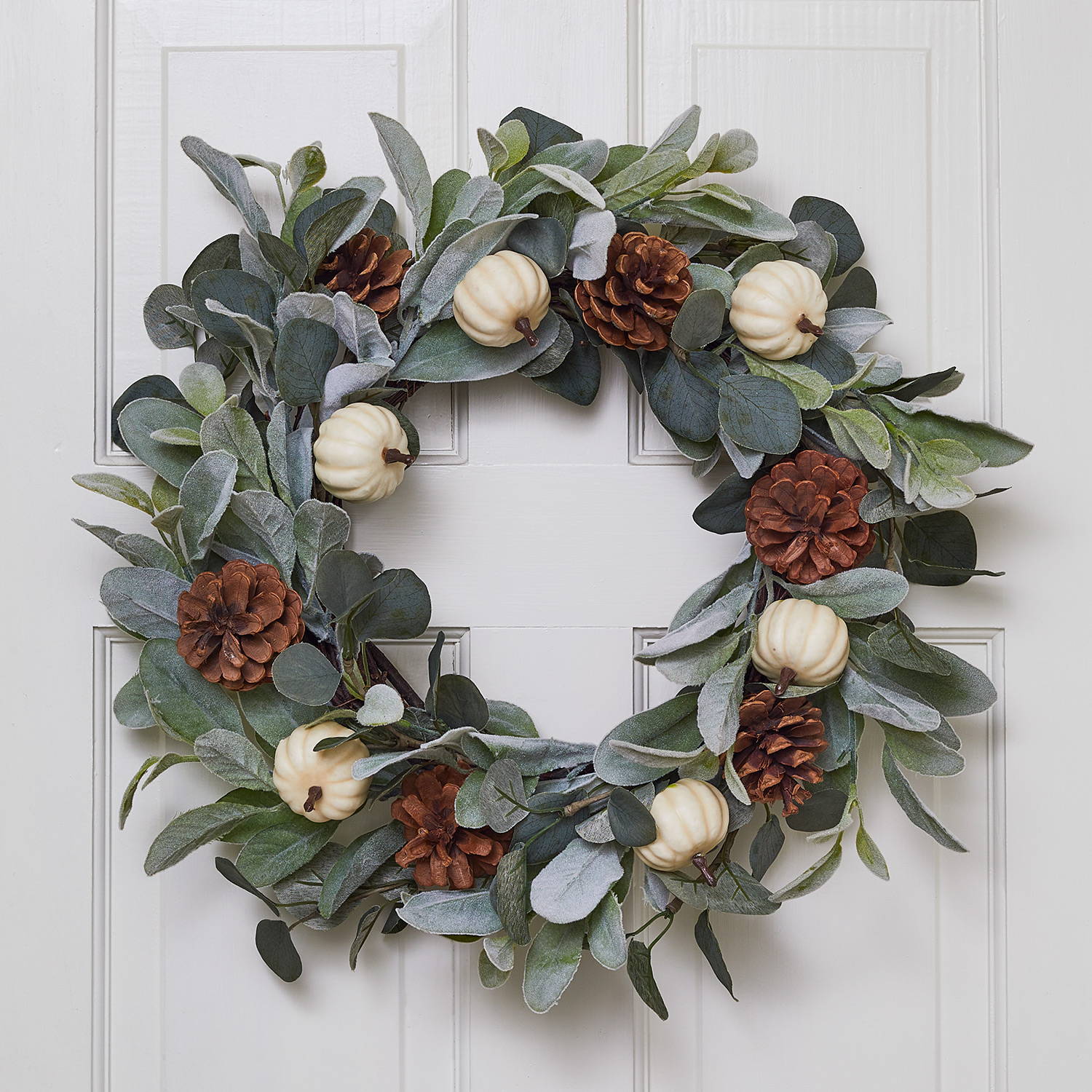 Autumnal green wreath on an internal door, featuring pumpkins