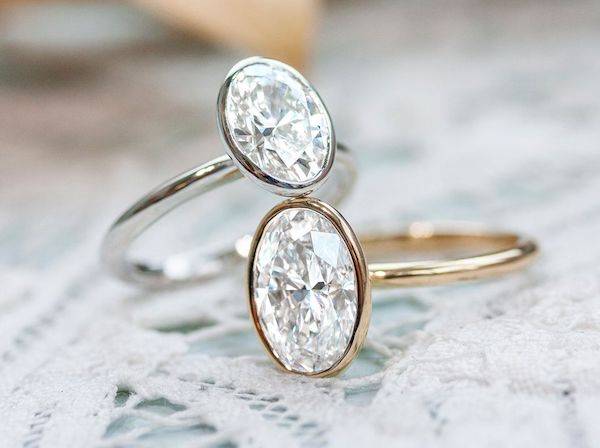 two oval diamond bezel set engagement rings