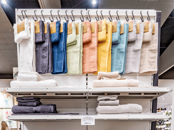 Colorful towels displayed on a rack in a store.