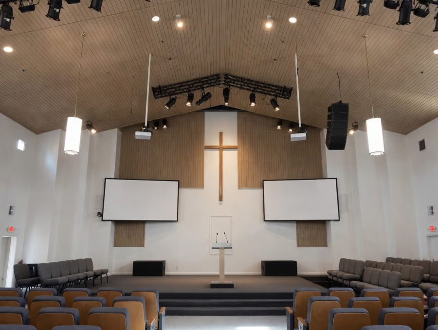 Interior of a church with a cross, pulpit, and seating.