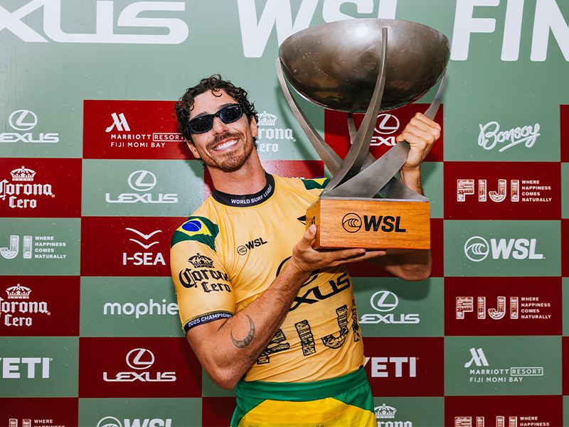 Athlete holding a trophy, wearing sunglasses, celebrating victory.