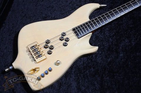 Electric guitar with a cream-colored body and multiple control knobs.